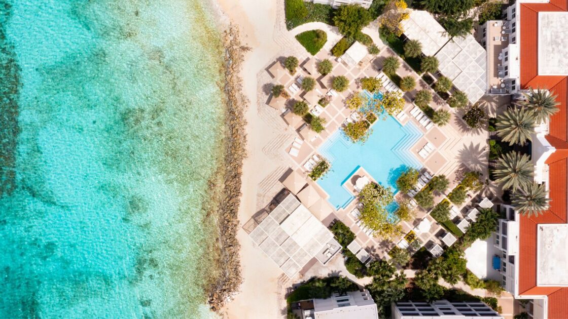 An aerial view of Curaçao Marriott Beach Resort, highlighting its grand pool and proximity to the ocean.
