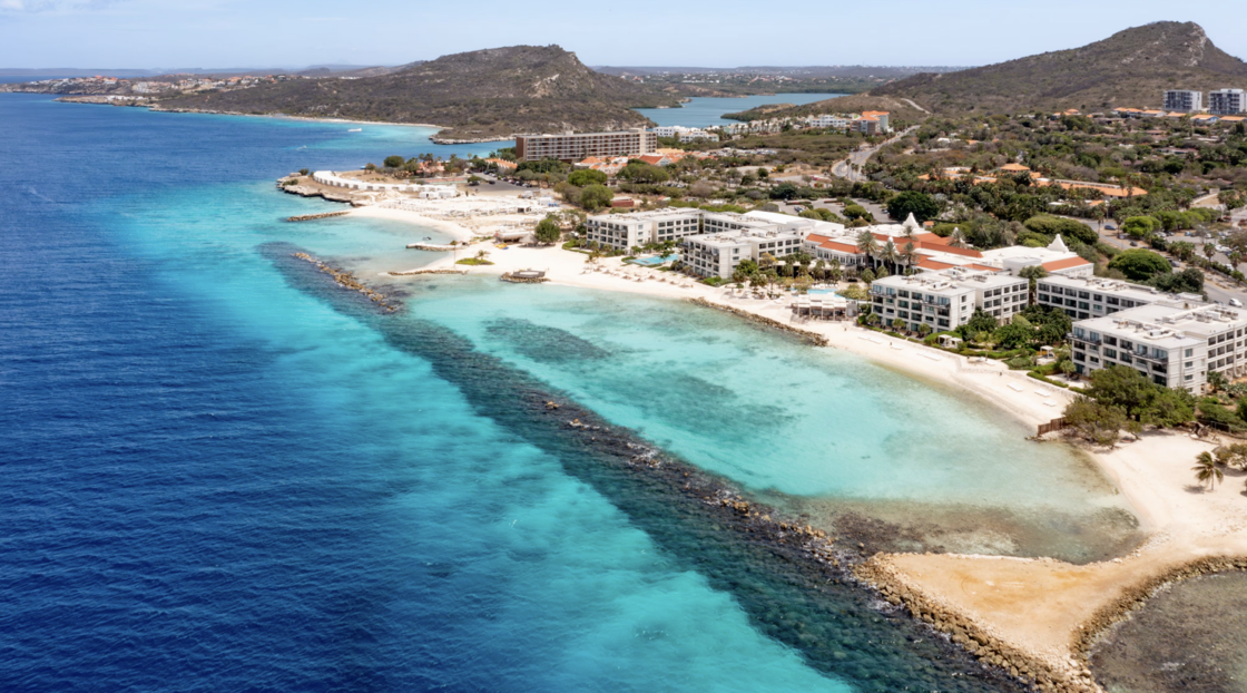 An aerial view of Curaçao, showcasing its blue waters and the Curaçao Marriott Beach Resort.
