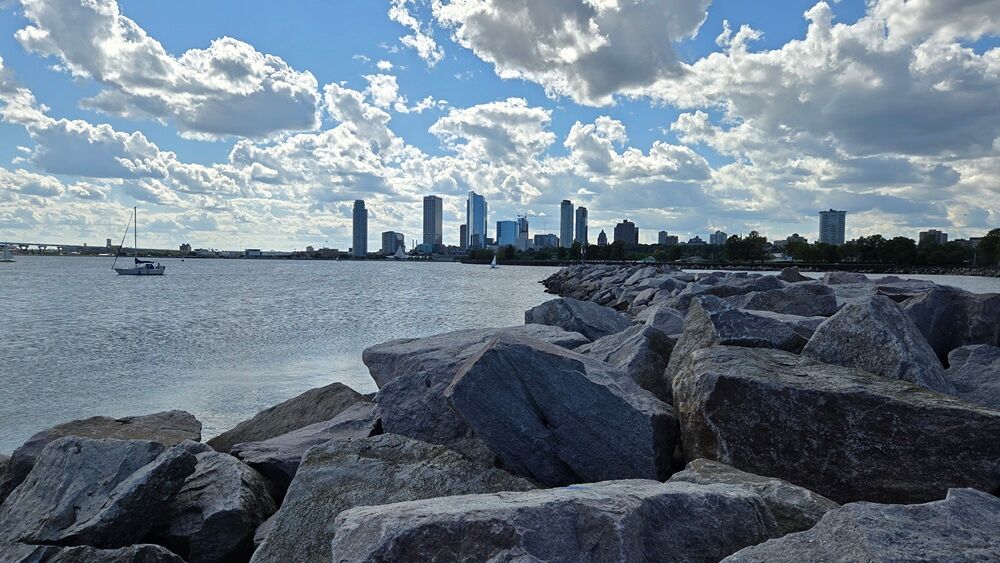 The Milwaukee skyline pictured in the distance during the afternoon, with a scenic cloudy sky.
