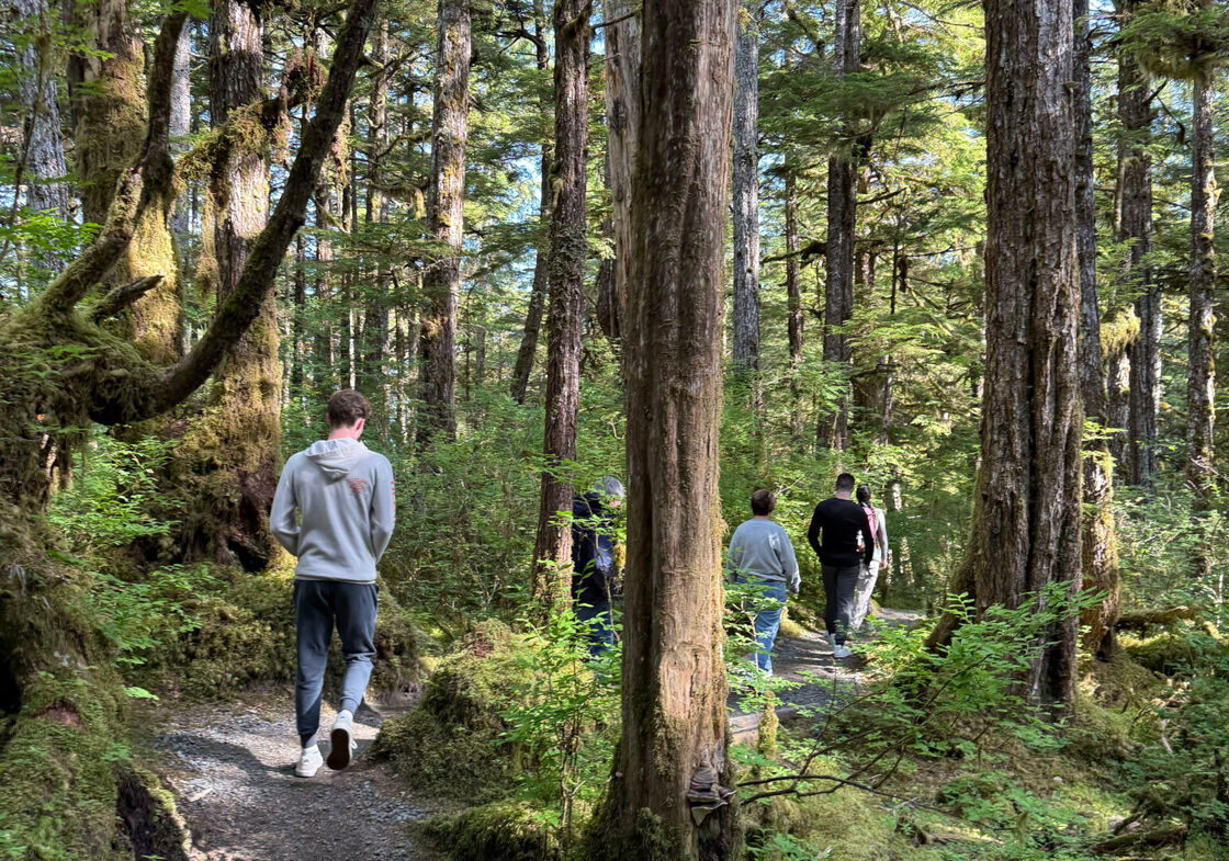 The author and his family walk through the lush green rainforest on a dirt path near Ketchikan, Alaska.