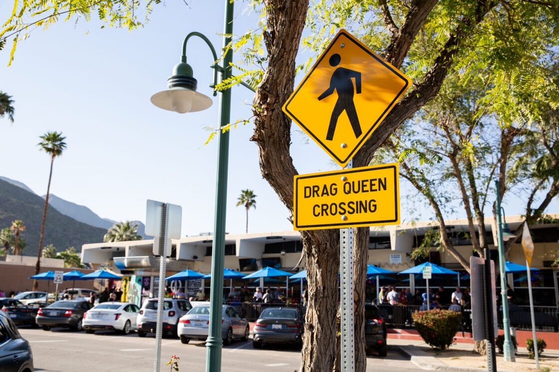 The streets of Palm Springs during Pride, where a "Drag Queen Crossing" sign is proudly displayed.