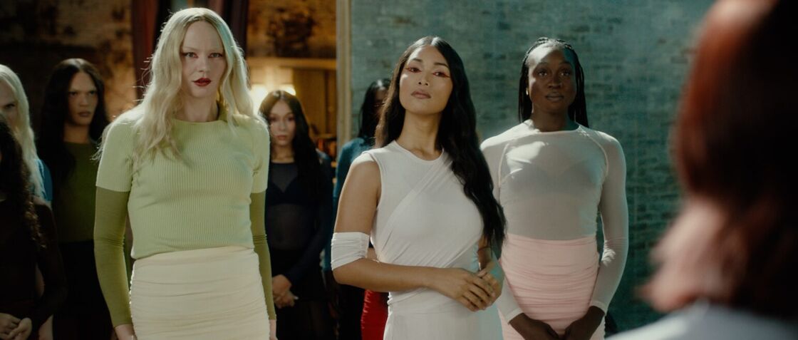 Geena Rocero poses in a white dress alongside other trans actresses in a scene from "Dolls."