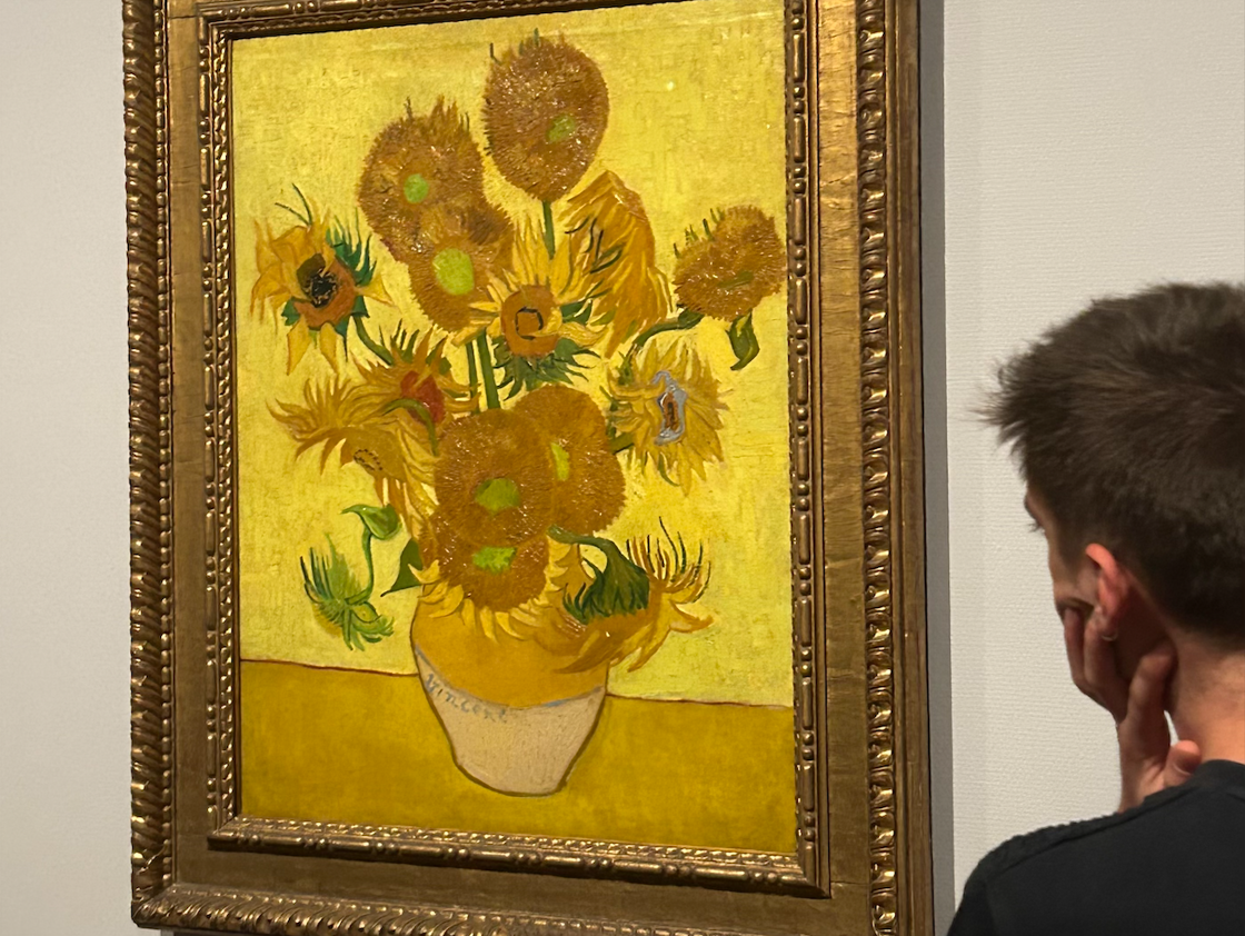 A young man thoughtfully looks at Vincent van Gogh's "Sunflower" painting on display at the Van Gogh Museum.