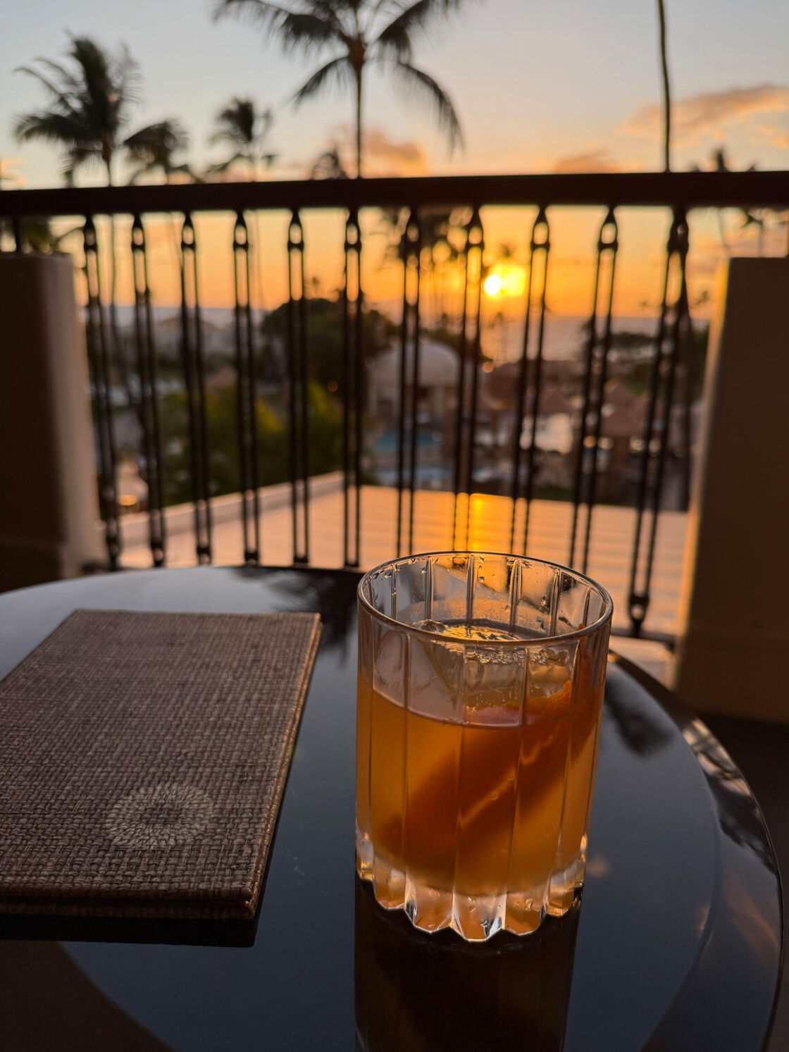 A glass of the Volcano House cocktail pictured on a lounge table at the Fairmont Kea Lani.