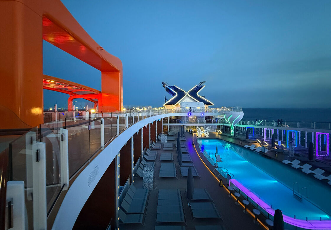 The pool deck of The Edge cruise ship, with the orange-trimmed Flying Carpet bar and restaurant pictured on the left.