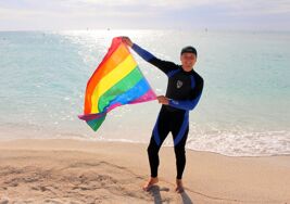 This sexy travel guru lives in a van and is literally flying the rainbow flag everywhere he goes