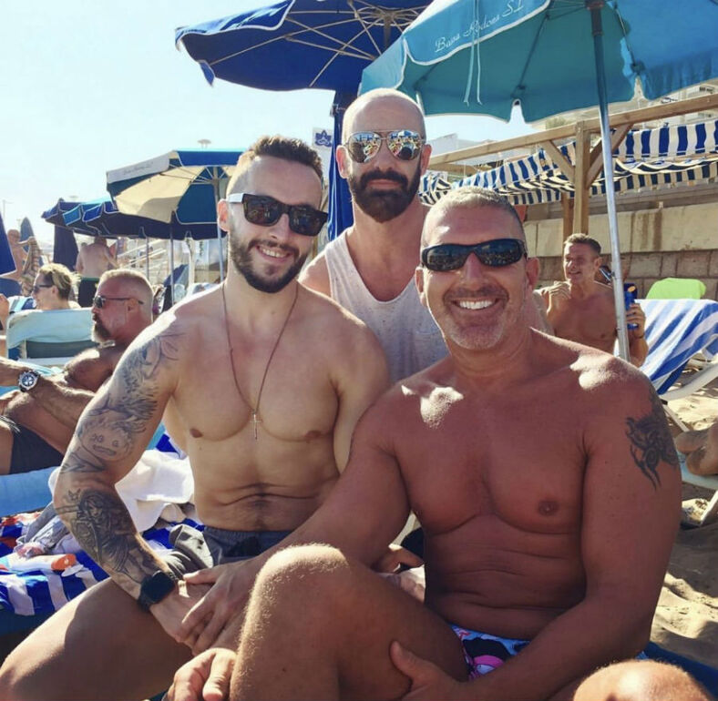 Group of men smiling together on the beach