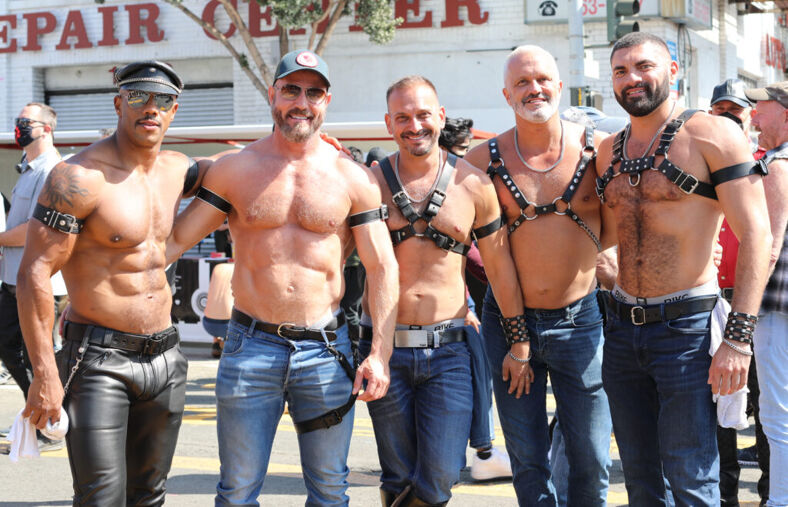 Five men wearing leather fashion accessories posing for the camera.