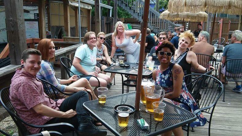 A group of people gathered around a patio table at Babes of Carytown.