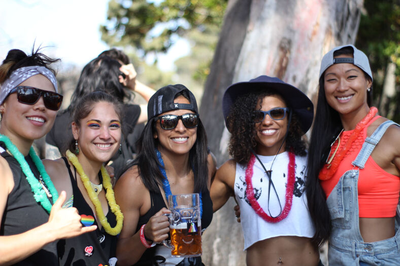 A group of festival goers smile at the camera while standing together