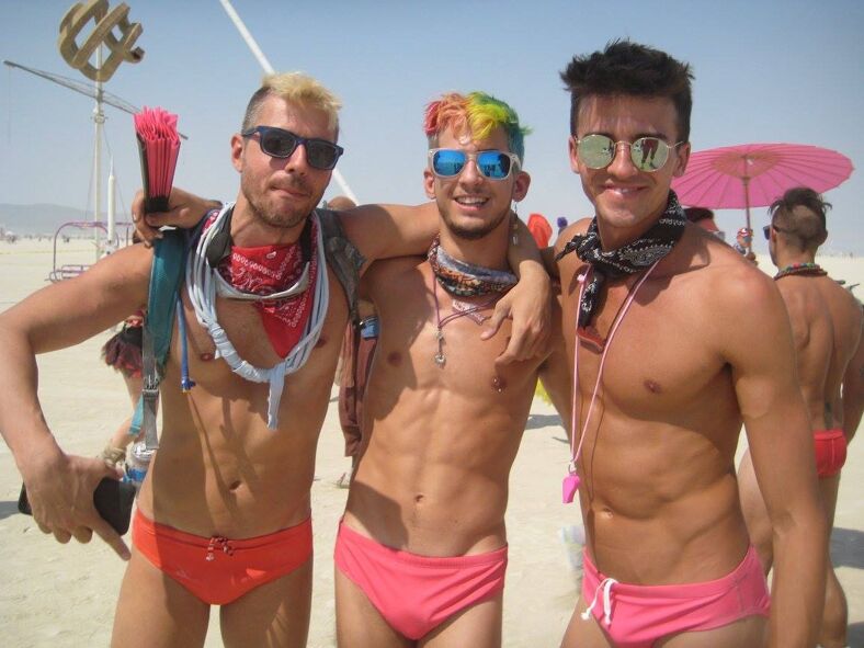 BamBam, Captain Rainbow, and Gage, members of the queer Burning Man camp Glamcocks, posing in the gayborhood of Black Rock City.