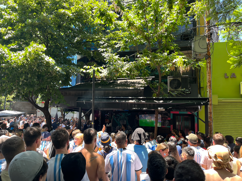 soccer fans watch the game through the window of a bar in Argentina.