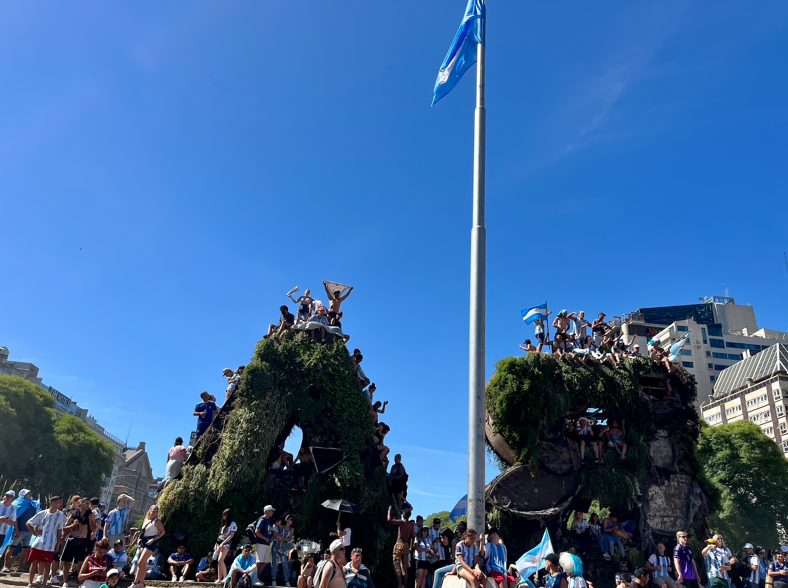 Soccer fans on top of two statues in Argentina.