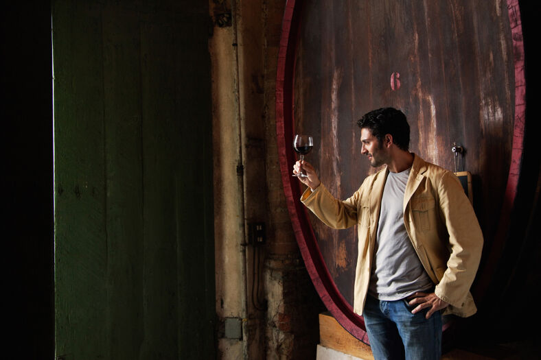 Man drinking red wine at cellar vineyard.