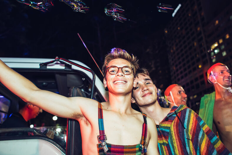 gay couple celebrating Sydney Mardis Gras at night.