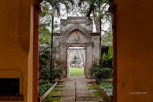 Ancient Mayan archway leading to a lush green lawn